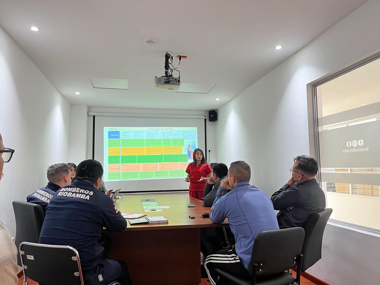 Psicóloga durante una sesión de capacitación con un equipo de trabajo